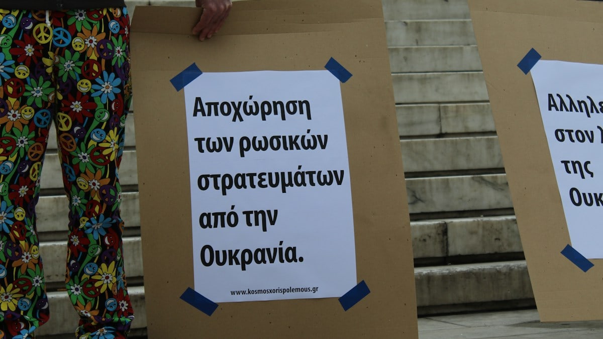 a couple of people standing next to each other holding signs