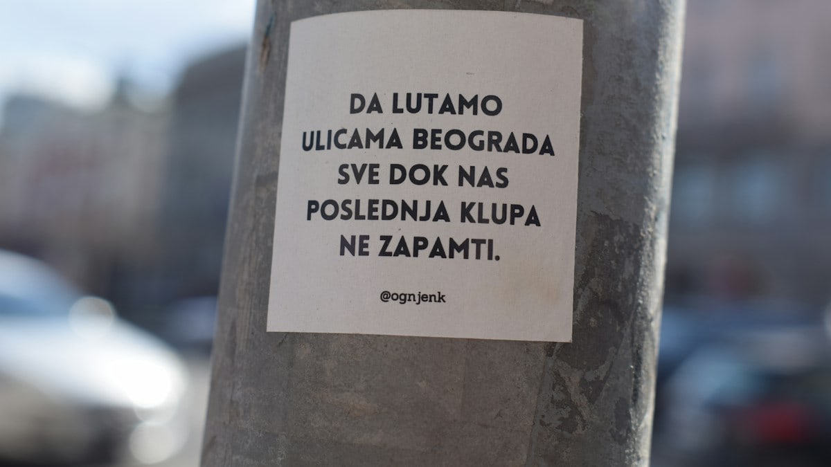 a sticker on a pole on a city street
